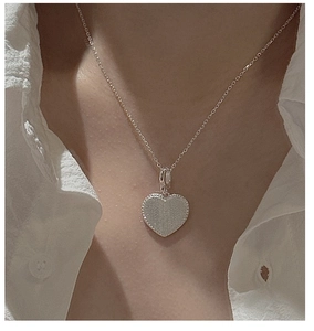 Vue détaillée d'un pendentif cœur en argent S925 avec bord perlé et finition brossée