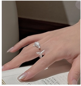 Detailed close-up of a matte S925 sterling silver whale dolphin wrap ring on a model