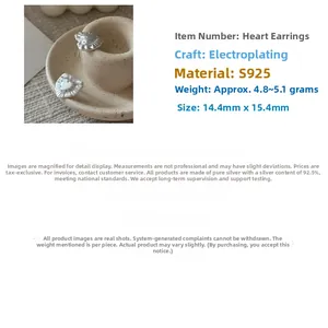 Detailed close-up of textured heart-shaped S925 sterling silver earrings on ceramic tray