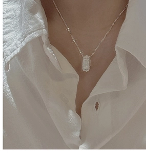Gros plan du collier en argent S925 avec pendentif cylindre martelé porté par un mannequin