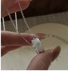 Gros plan du collier en argent sterling S925 avec un pendentif anneau à texture vintage