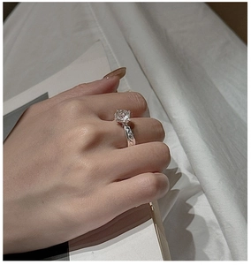 Macro detail of S925 silver ring with clear crystal stone and twisted rope band texture
