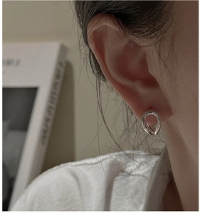 Close-up of minimalist S925 sterling silver curved earring on model's ear