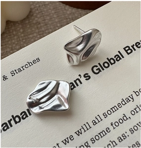 Macro view of S925 sterling silver earrings featuring irregular wrinkled metal texture