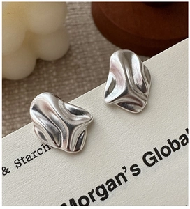 Macro view of S925 sterling silver earrings with irregular textured lava design