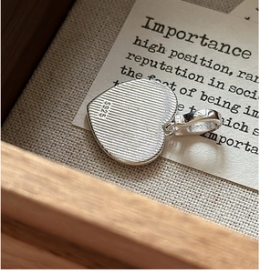 Vue macro du pendentif cœur en argent sterling S925 avec texture brossée et poinçon
