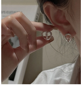 Close-up of minimalist S925 sterling silver interlocking hoop earrings on model