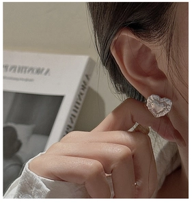 Close-up of S925 silver heart earring with vintage textured edges worn by a model