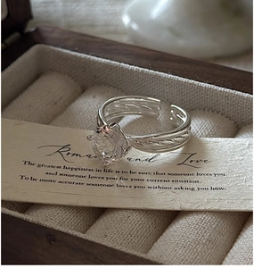Detail of S925 silver adjustable ring with round crystal and twisted braided band
