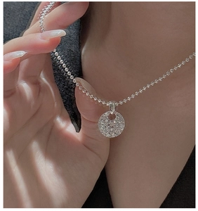 Macro detail of 925 sterling silver necklace with glittering round CNC crystal pendant
