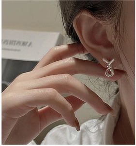 Close-up of S925 sterling silver twist hoop earrings worn on model for modern style