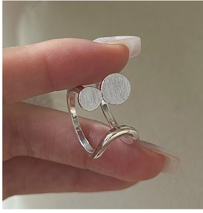 Detail of S925 sterling silver wavy open ring with brushed metal circular charms