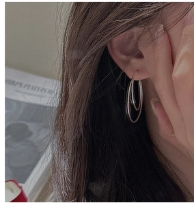 Close-up of minimalist S925 sterling silver double hoop earrings on a female model