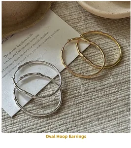 Gros plan de boucles d'oreilles créoles dorées et argentées avec texture ondulée