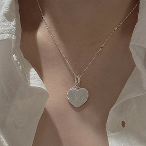 Collier avec pendentif cœur en argent sterling S925 avec bordure perlée sur chemise blanche
