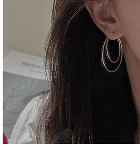 Close-up of minimalist S925 sterling silver double hoop earrings worn on model's ear
