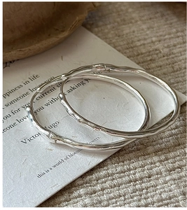 Détail macro de créoles en argent sterling S925 avec design de texture bambou naturel