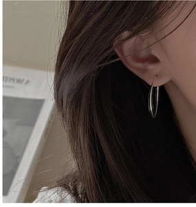 Close-up of minimalist S925 sterling silver hoop earrings worn on a female ear