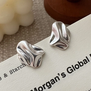 Minimalist S925 sterling silver earrings with irregular lava texture on white display card