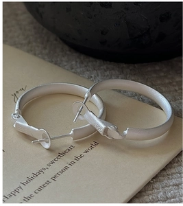 Macro shot of S925 sterling silver hoop earrings with matte finish and hallmark engraving