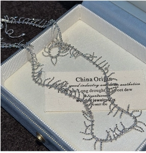 Detailed shot of a vintage S925 silver fringe necklace inside a blue premium jewelry box