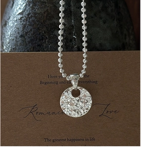 Close-up of S925 sterling silver necklace with textured circular pendant and CNC hammer finish