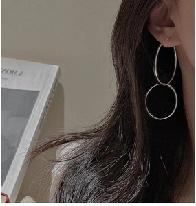 Detail of minimalist S925 sterling silver double hoop earrings worn by a model