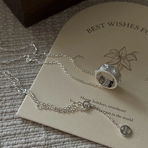 Collier en argent sterling S925 avec pendentif cylindrique sur carte cadeau beige