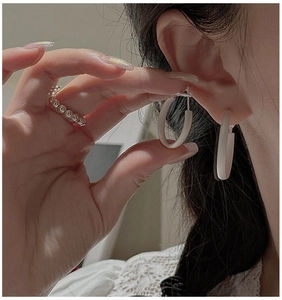 Macro detail of matte S925 sterling silver hoop earrings and textured sphere ring