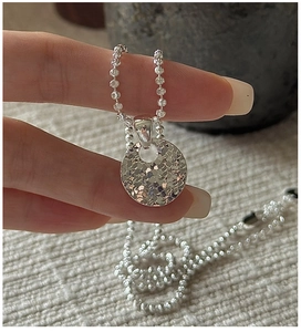 Detailed close-up of 925 sterling silver ball chain necklace with hammered round pendant