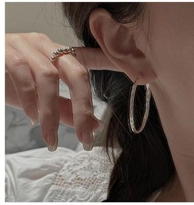 Gros plan de boucles d'oreilles en argent martelé et bague perle avec dentelle