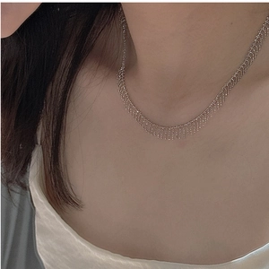Close-up of S925 sterling silver tassel necklace with delicate beads on a model's neck