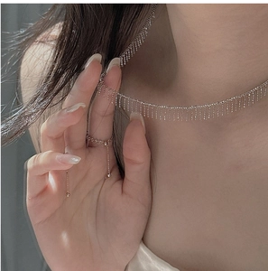 Detail of S925 sterling silver tassel necklace and ring set on model skin