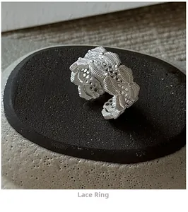 Macro detail of S925 sterling silver lace ring with intricate hollow texture on stone base