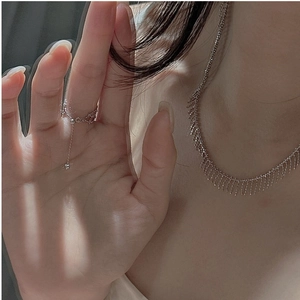 Macro shot of S925 silver fringe necklace and matching tassel ring worn on skin