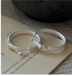 Close-up of S925 sterling silver stamp and matte texture on minimalist hoop earrings