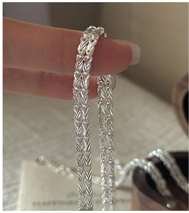 Macro shot of S999 sterling silver woven bracelet with vintage shimmering metal texture