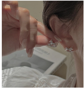 Detail view of S925 silver rocking horse earrings with shimmering stone texture on model