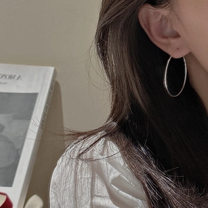 Minimalist S925 sterling silver hoop earrings with a polished finish worn by a model