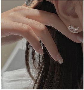 Detailed macro view of S925 sterling silver rocking horse stud earring on ear