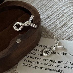 Elegant S925 sterling silver knot stud earrings displayed on a luxury wooden box