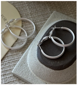 Macro detail of S925 sterling silver hoop earrings with a matte brushed finish texture