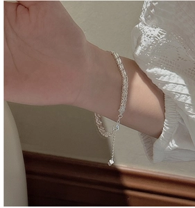 Close-up of S999 sterling silver braided bracelet with a heart charm extension chain