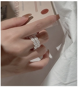 Macro shot of S925 sterling silver hollow lace ring on finger with vintage floral pattern