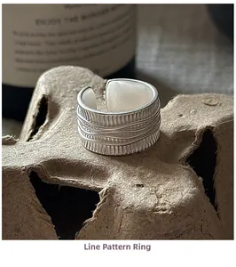 Détail d'une bague en argent sterling S925 avec textures verticales et fil métallique