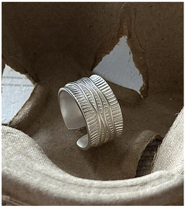 Vue macro d'une bague en argent S925 avec textures verticales et détails de fils