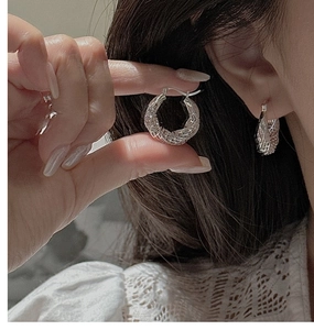 Macro detail of S925 sterling silver hoop earrings with vintage twisted rope texture