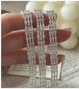 Gros plan sur une chaîne maillée multicouche en argent S999 à texture souple et brillante