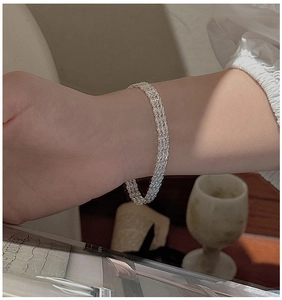 Détail d'un bracelet multicouche en argent sterling S999 sur le poignet d'une femme