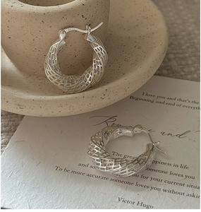 Macro shot of S925 sterling silver hoop earrings with hollow mesh twisted design